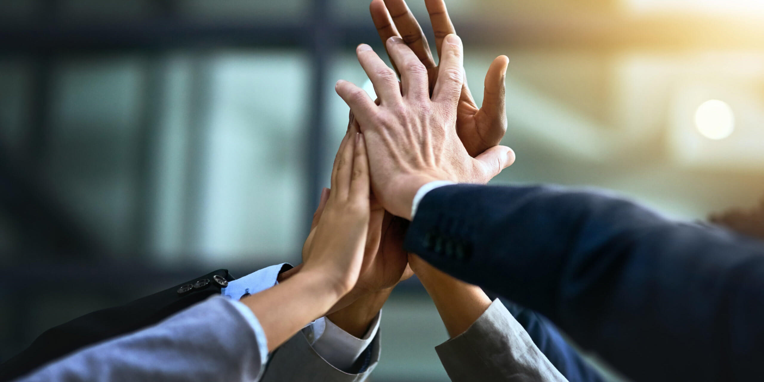 Cropped shot of a group of businesspeople joining their hands in solidarity